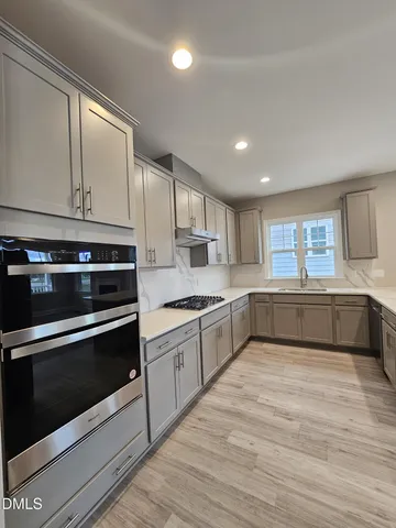a kitchen with stainless steel appliances granite countertop a stove a sink and a microwave