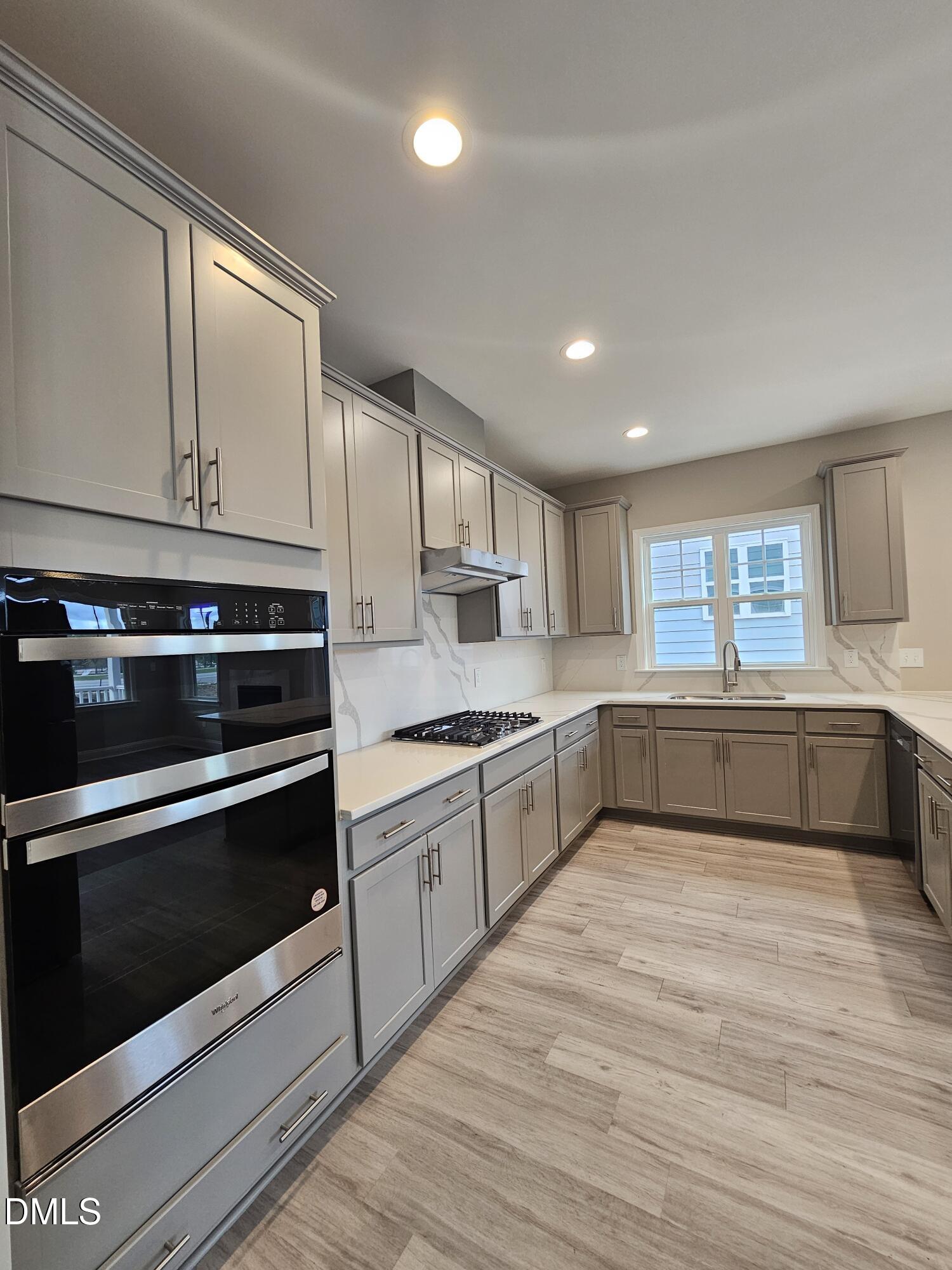 7994 Humie Olive Road Apex, NC 27502 - Photo 5 of 14 a kitchen with stainless steel appliances granite countertop a stove a sink and a microwave