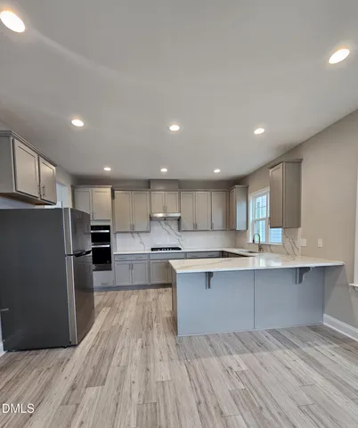 a large kitchen with kitchen island a sink a stove a refrigerator and a cabinets