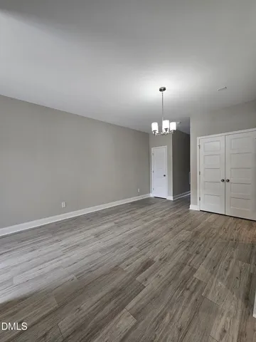 an empty room with wooden floor and mirror