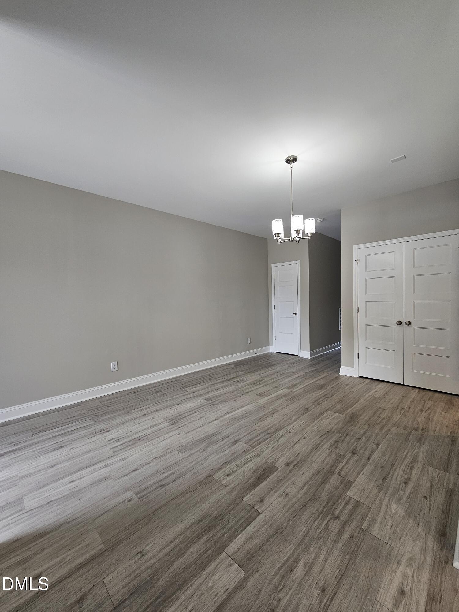 7994 Humie Olive Road Apex, NC 27502 - Photo 7 of 14 an empty room with wooden floor and mirror