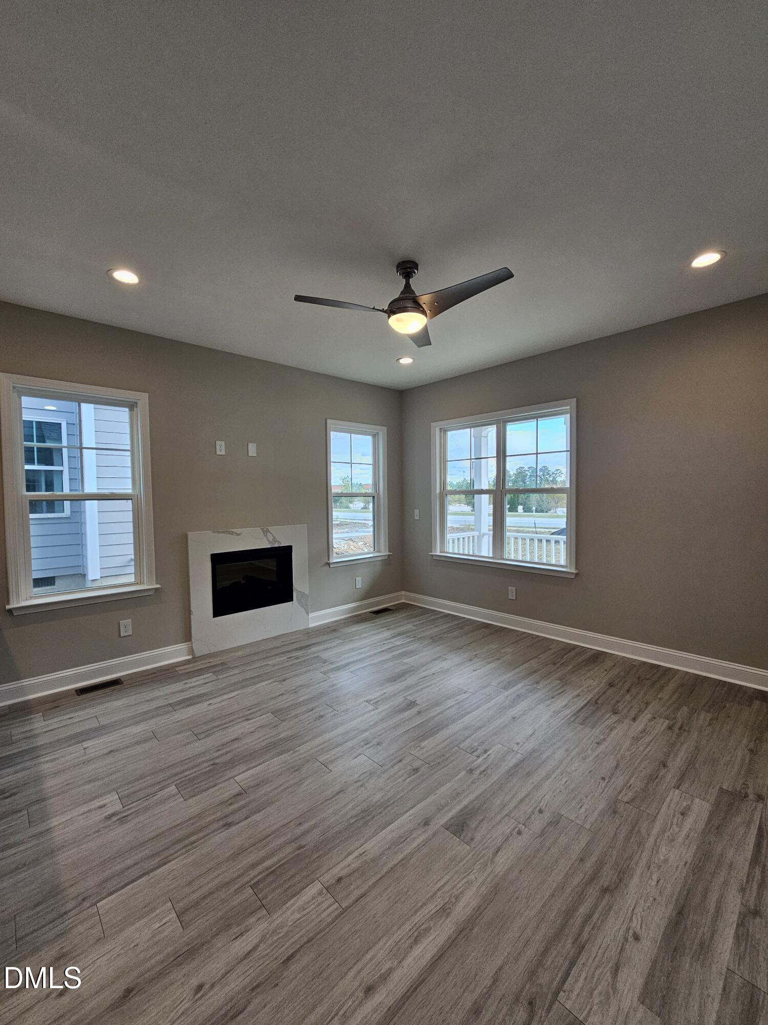 7994 Humie Olive Road Apex, NC 27502 - Photo 10 of 14 an empty room with wooden floor and windows