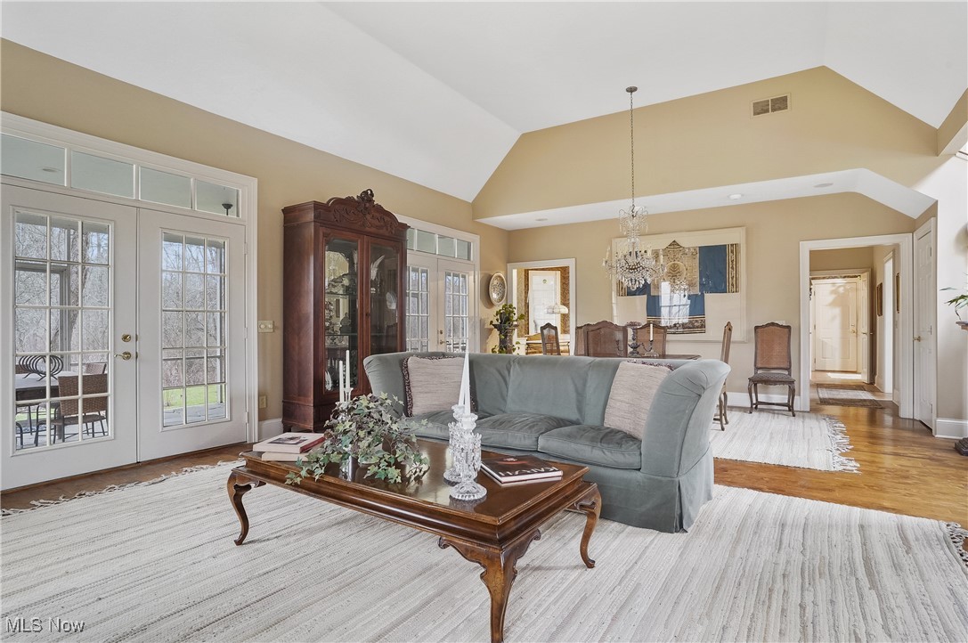 5612 Ridge Road Wadsworth, OH 44281 - Photo 4 of 33 Living room with high vaulted ceiling, a chandelier, light hardwood / wood-style floors, and french doors