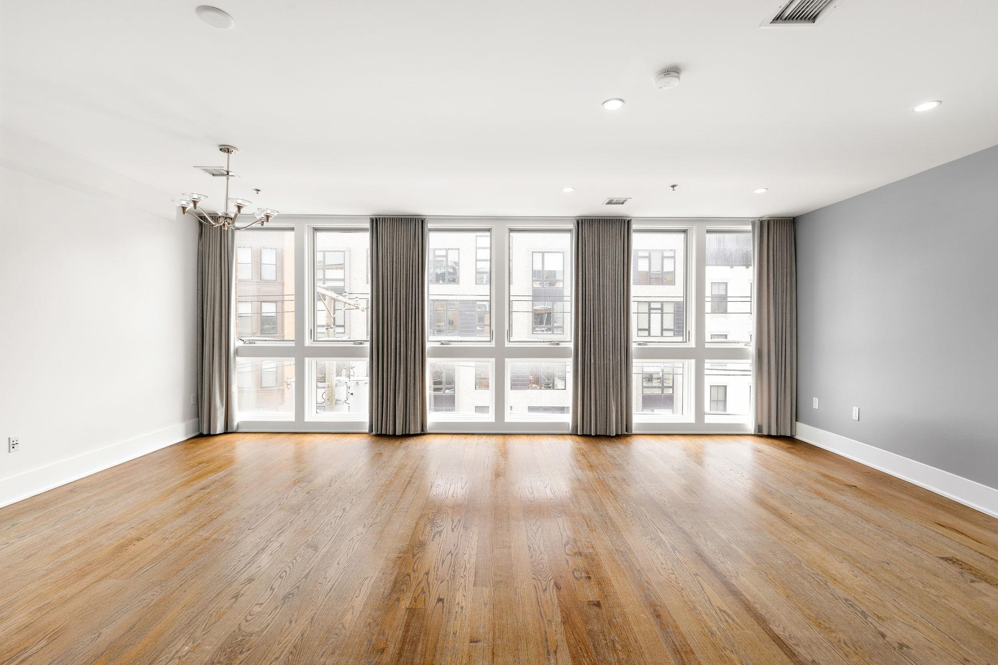89 Jefferson Street, Unit 4B Hoboken, NJ 07030 - Photo 4 of 16 a view of an empty room with wooden floor and a window