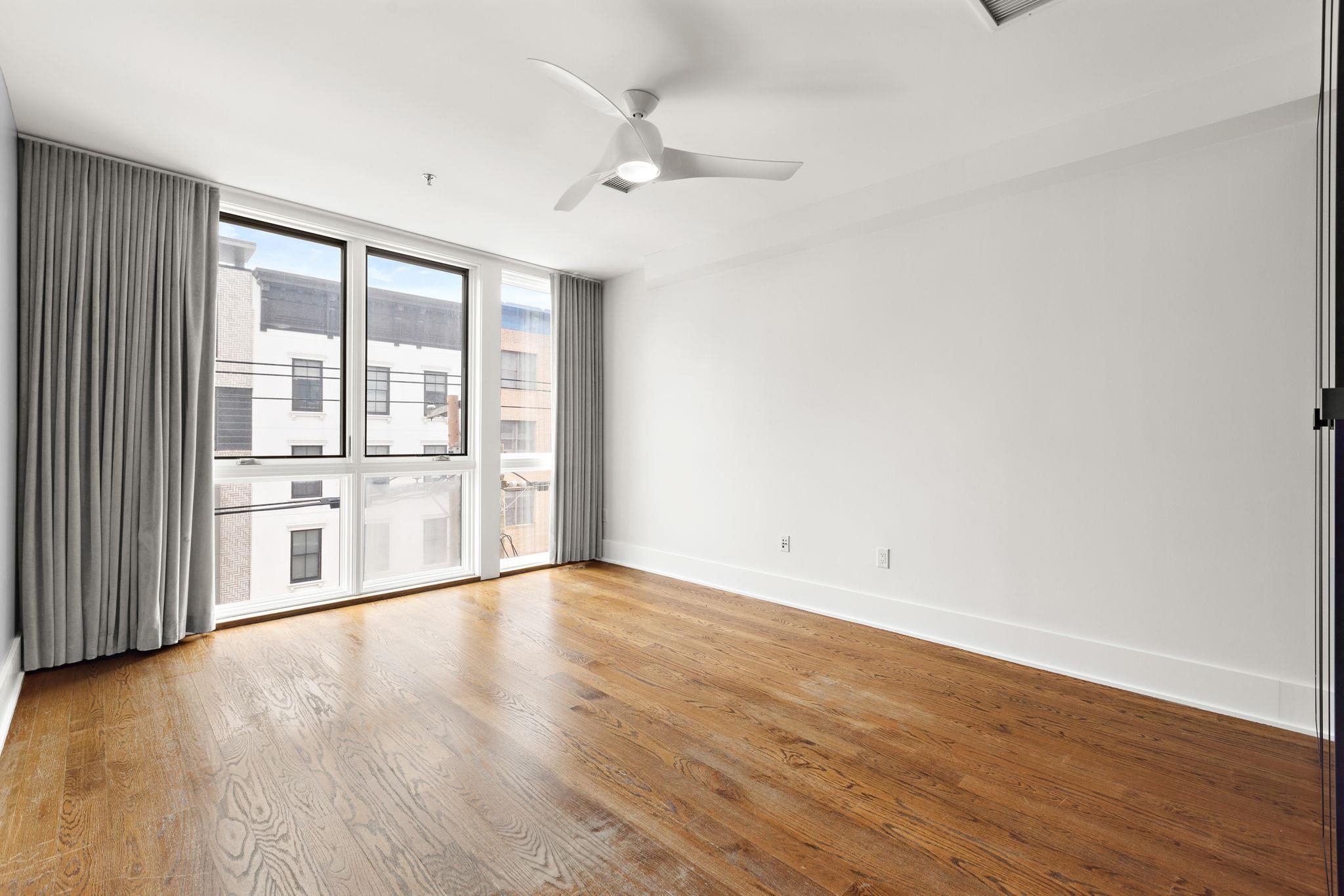 89 Jefferson Street, Unit 4B Hoboken, NJ 07030 - Photo 8 of 16 a view of an empty room with wooden floor and a window