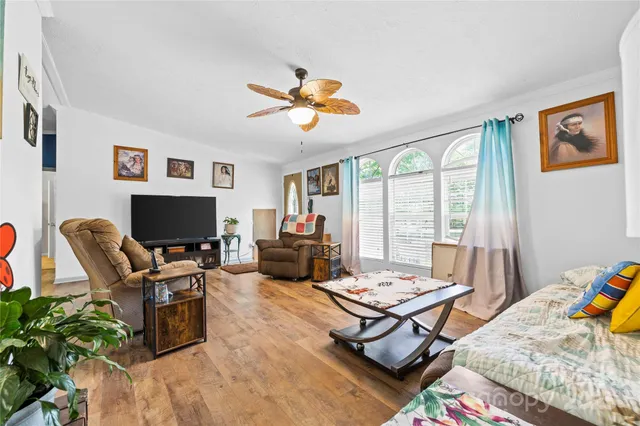 a living room with furniture a flat screen tv and a large window