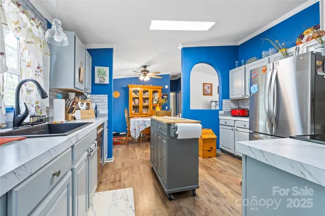 a kitchen with stainless steel appliances granite countertop a sink a stove and a refrigerator