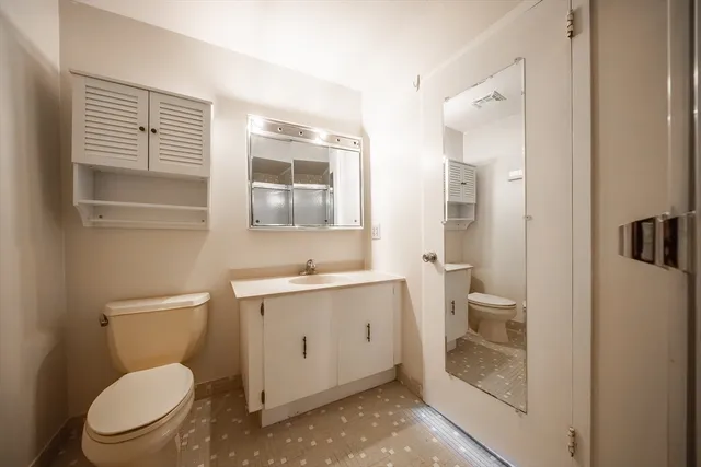 a bathroom with a toilet a sink and glass door