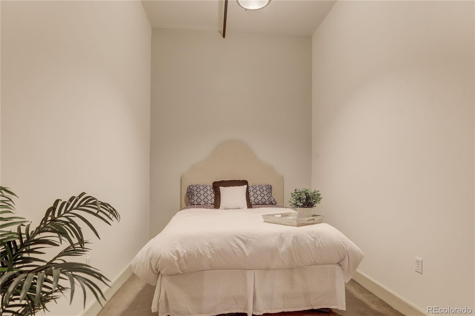 2500 Walnut Street, Unit 212 Denver, CO 80205 - Photo 11 of 39 a bedroom with a bed and a mirror
