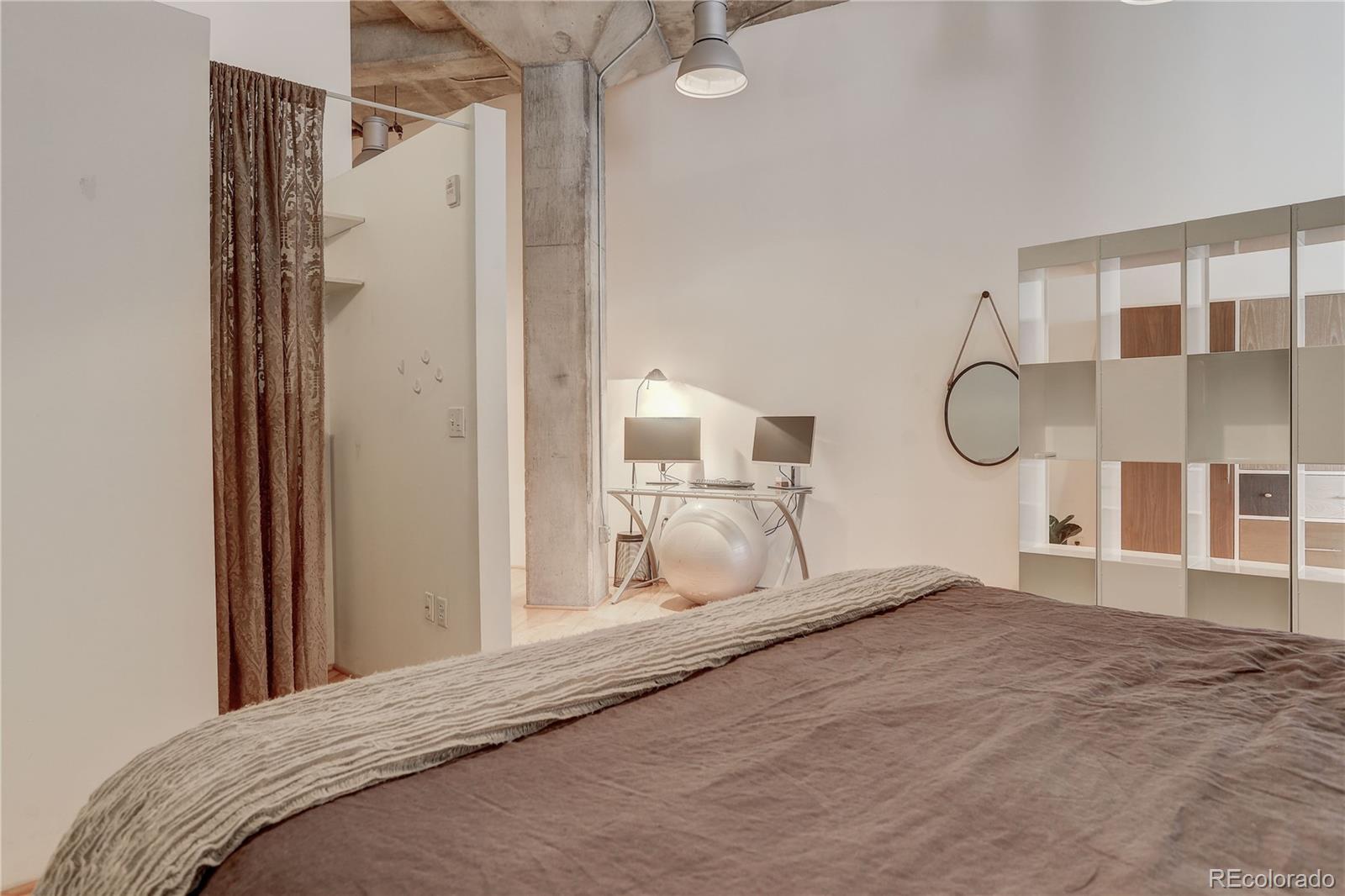 2500 Walnut Street, Unit 212 Denver, CO 80205 - Photo 19 of 39 a bedroom with a bed and a mirror