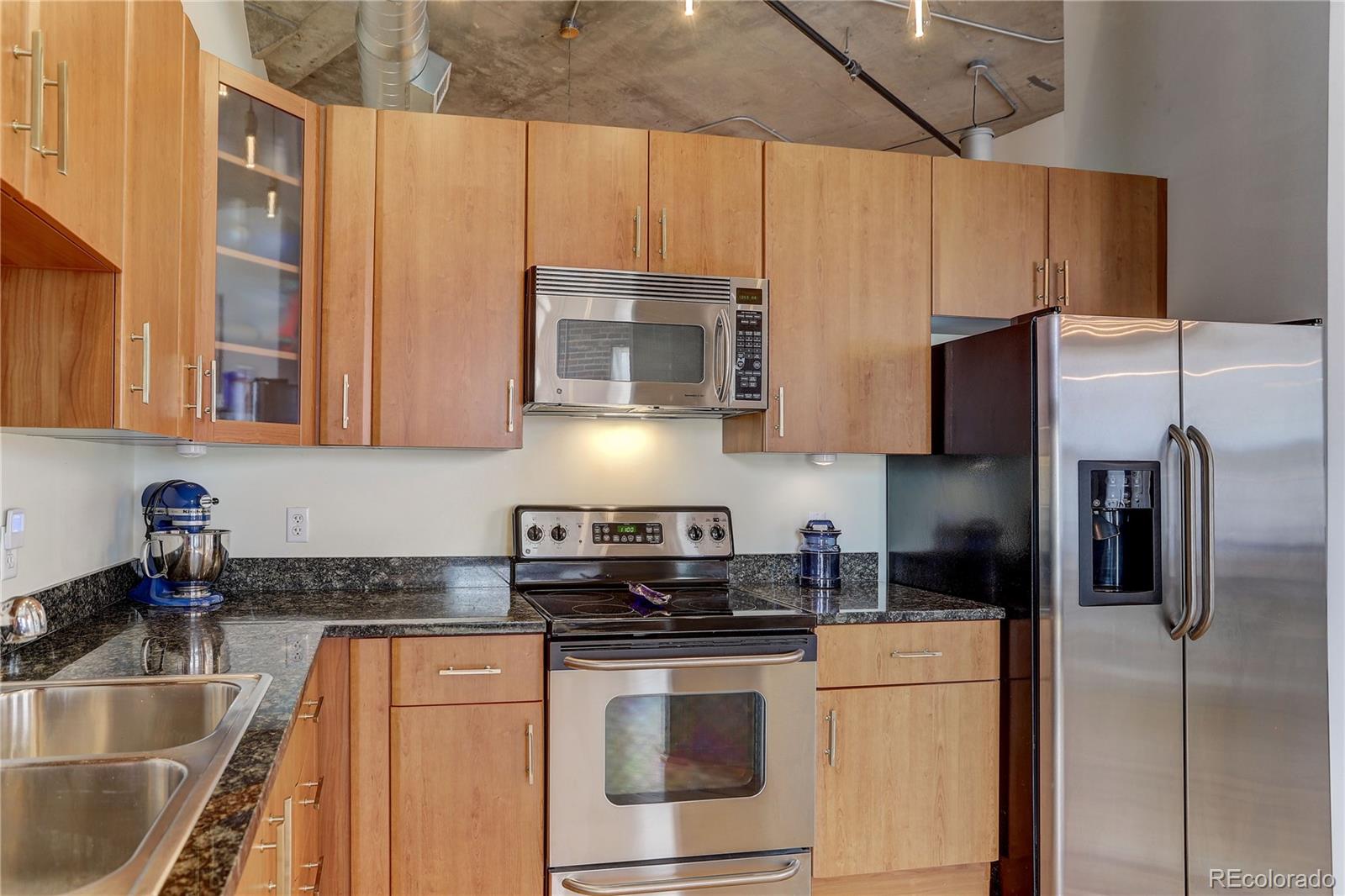2500 Walnut Street, Unit 212 Denver, CO 80205 - Photo 28 of 39 a kitchen with stainless steel appliances granite countertop a sink a stove a refrigerator a washer dryer and white cabinets