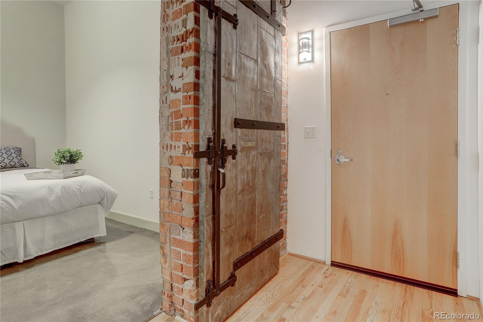 2500 Walnut Street, Unit 212 Denver, CO 80205 - Photo 10 of 39 a bedroom with a bed and a mirror