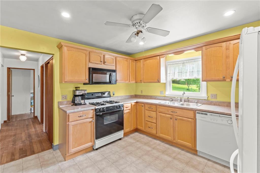 17 Ellen Drive McKees Rocks, PA 15136 - Photo 7 of 31 a kitchen with stainless steel appliances granite countertop a stove top oven a sink dishwasher a dining table and chairs with wooden floor