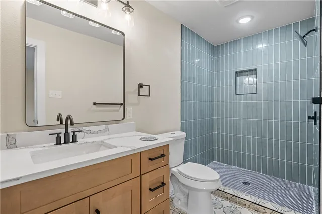 a bathroom with a sink a toilet and shower