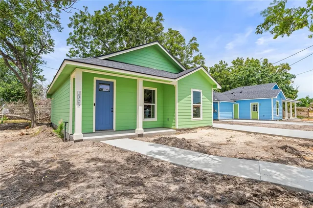 a front view of a house with a garden and trees