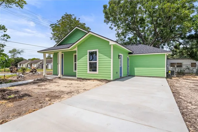 a front view of a house with a garden and garage