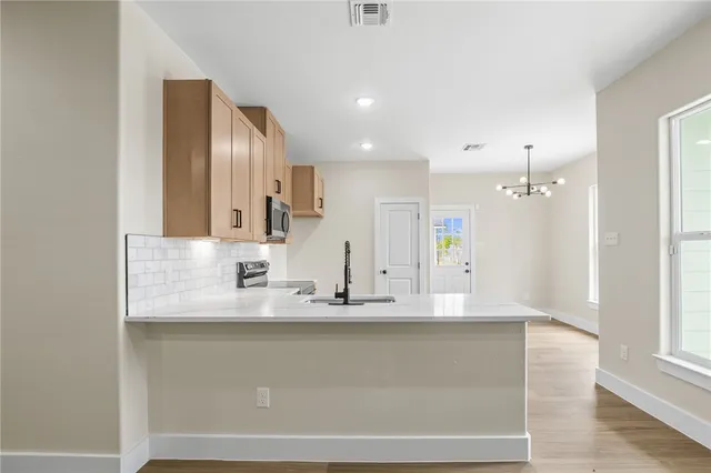 a kitchen with granite countertop white cabinets and stainless steel appliances