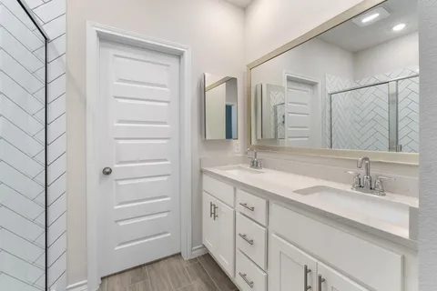a bathroom with a double vanity sink and mirror