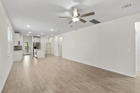 a view of an empty room with wooden floor