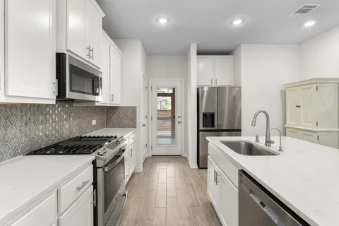 a kitchen with stainless steel appliances granite countertop a stove microwave and sink