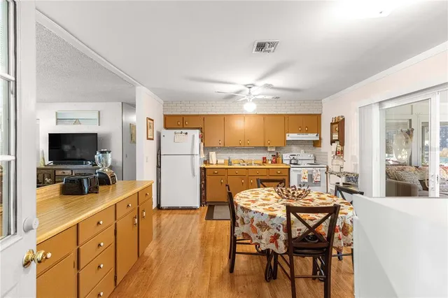 a view of a dining room with furniture a kitchen and chandelier