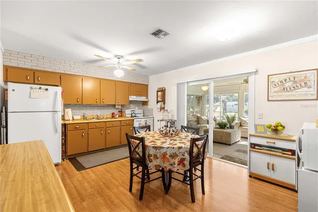 a kitchen with a dining table chairs and refrigerator