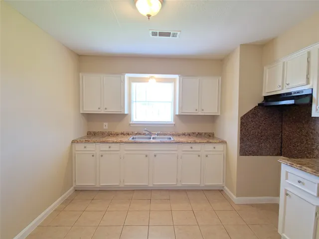 a kitchen with granite countertop white cabinets and white appliances