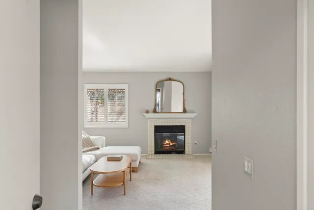 a living room with furniture a fireplace and a window