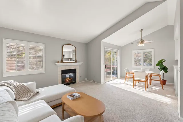 a living room with furniture a fireplace and a large window