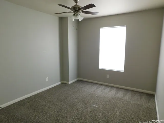 an empty room with a empty space and a ceiling fan view