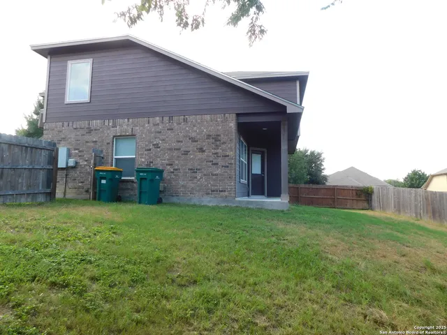 a brick house with a yard plants in front of it