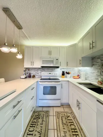 a kitchen with a sink stove and cabinets