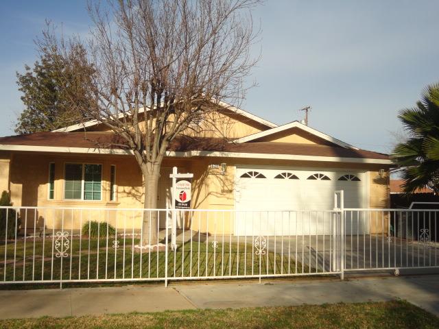 521 W West 9th Street Merced, CA 95341 - Photo 1 of 21 a view of a brick house with a large trees next to a road