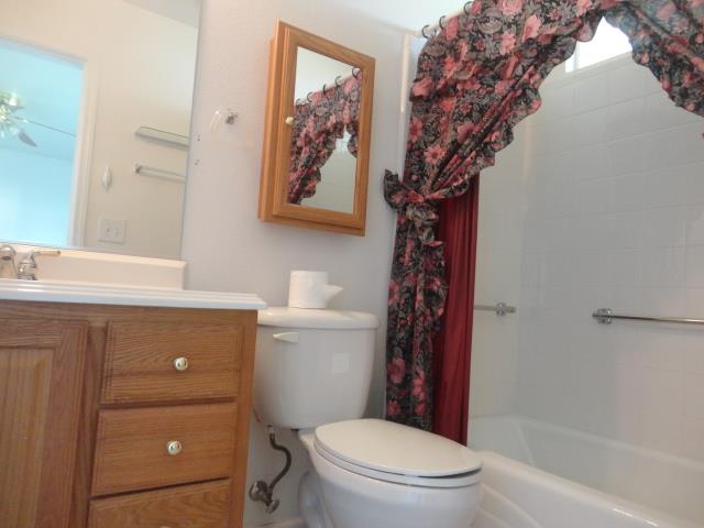 521 W West 9th Street Merced, CA 95341 - Photo 14 of 21 a bathroom with a toilet sink and mirror
