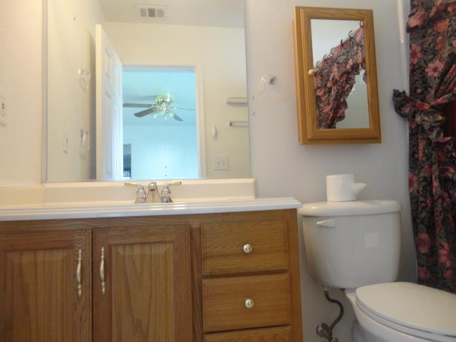 521 W West 9th Street Merced, CA 95341 - Photo 15 of 21 a bathroom with a granite countertop toilet a sink and a mirror