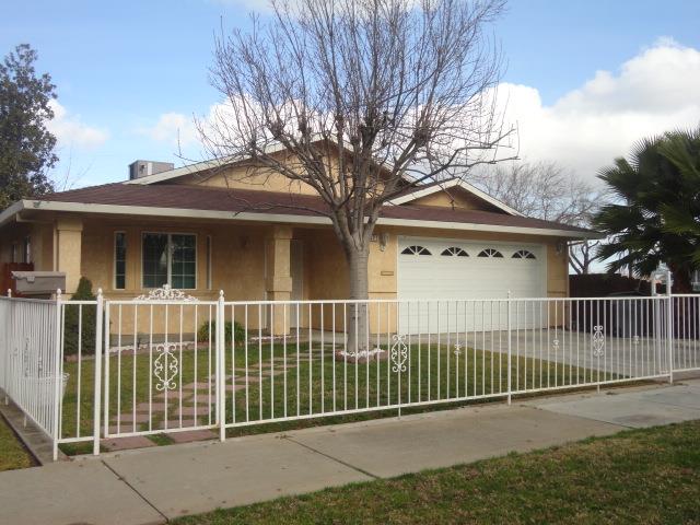 521 W West 9th Street Merced, CA 95341 - Photo 2 of 21 a view of a house with a fence and a large tree