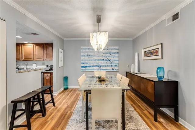 a view of a dining room with furniture a chandelier and wooden floor
