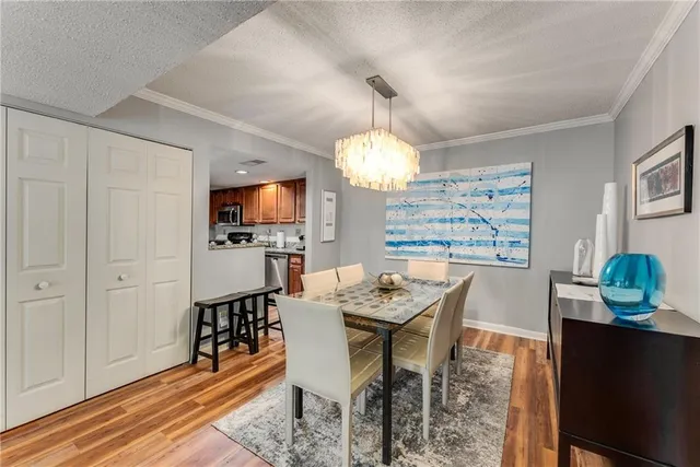 a view of a dining room with furniture a chandelier and wooden floor