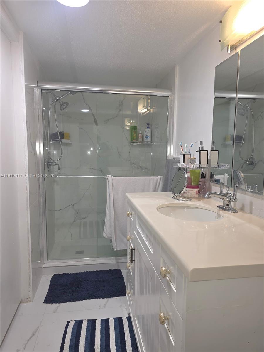 575 Vero Avenue Clewiston, FL 33440 - Photo 14 of 32 a bathroom with a sink a mirror and shower