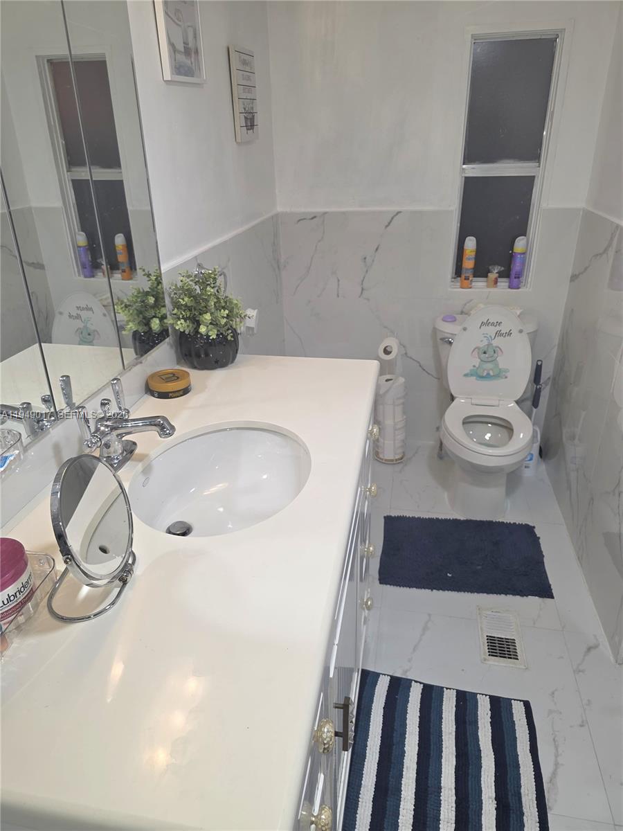 575 Vero Avenue Clewiston, FL 33440 - Photo 22 of 32 a bathroom with a sink and a mirror