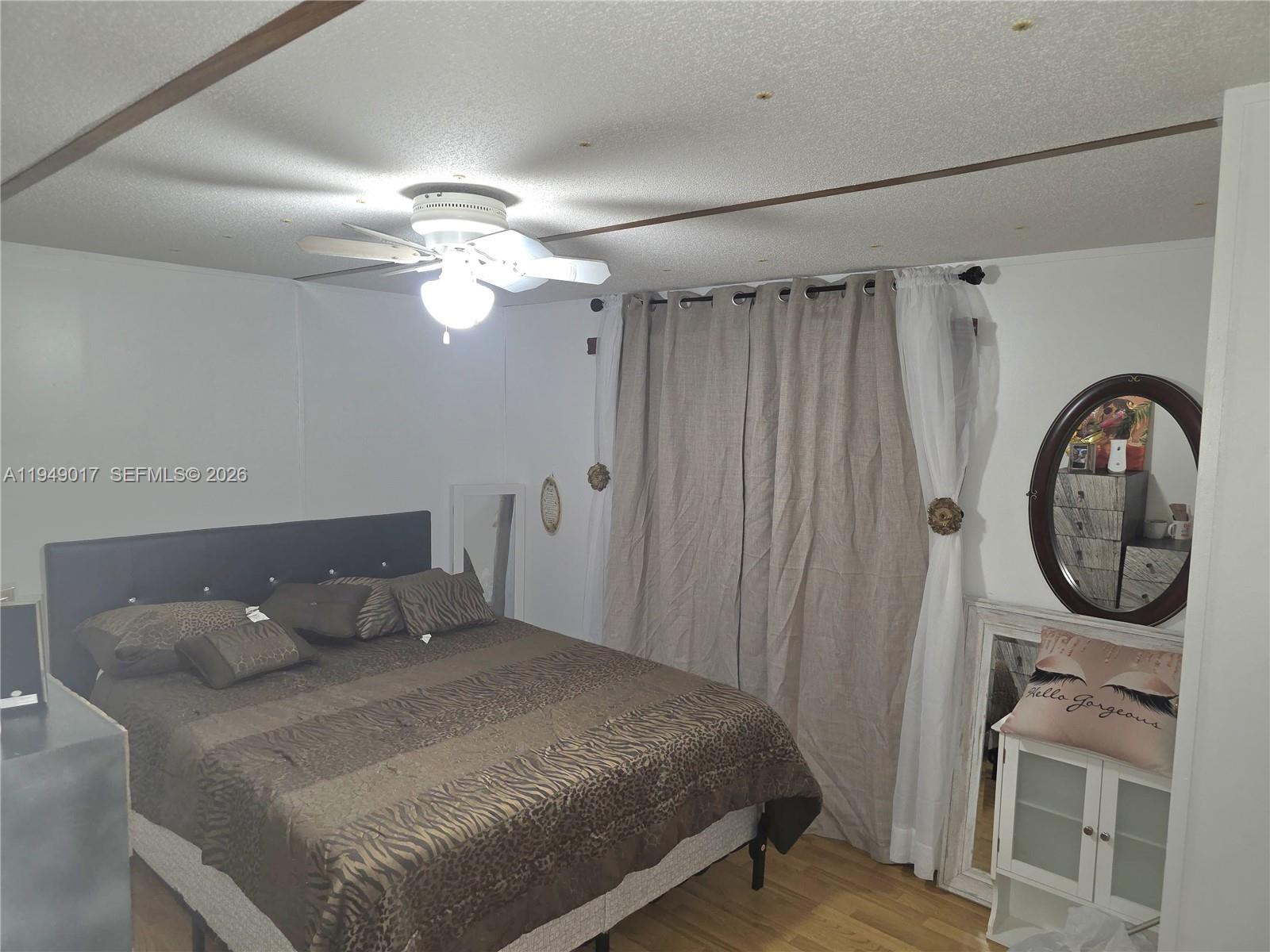 575 Vero Avenue Clewiston, FL 33440 - Photo 25 of 32 a bedroom with a bed and a chandelier