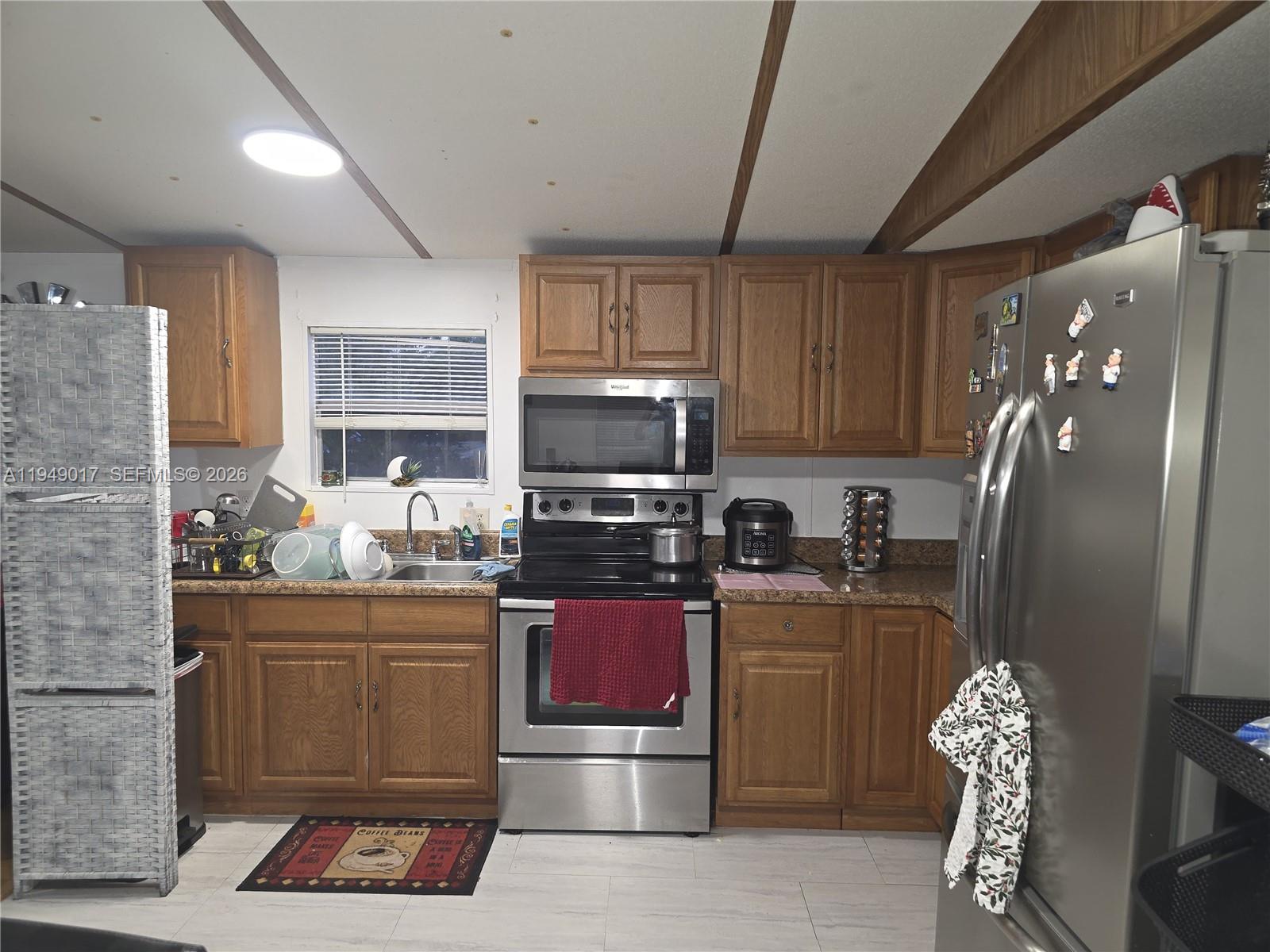 575 Vero Avenue Clewiston, FL 33440 - Photo 27 of 32 a kitchen with stainless steel appliances granite countertop a refrigerator stove and microwave