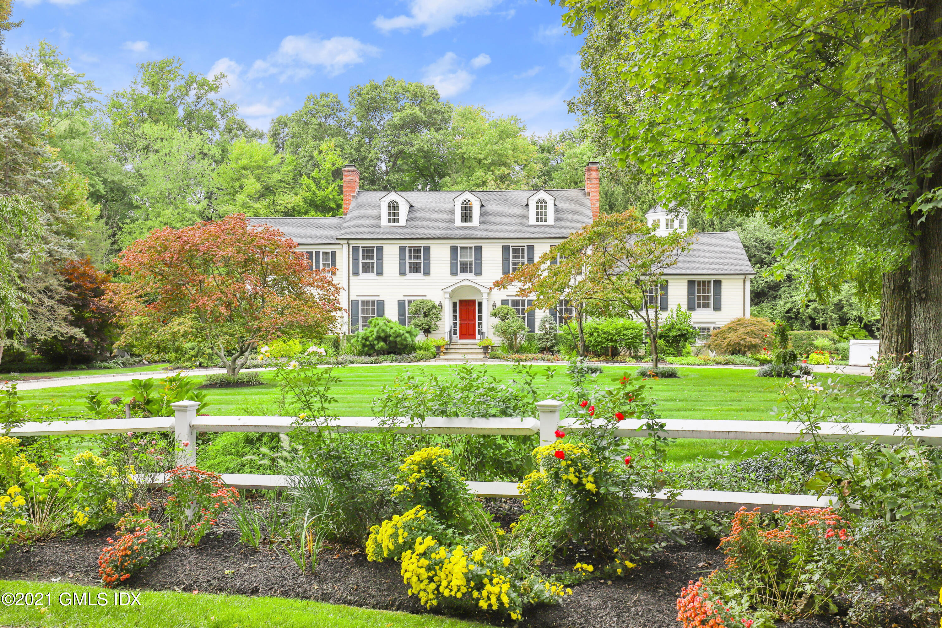 a front view of a house with a yard and potted plants