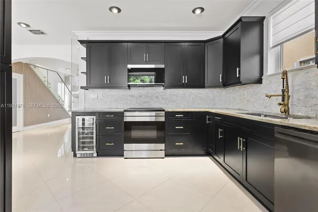 a kitchen with stainless steel appliances granite countertop a sink and stove top oven