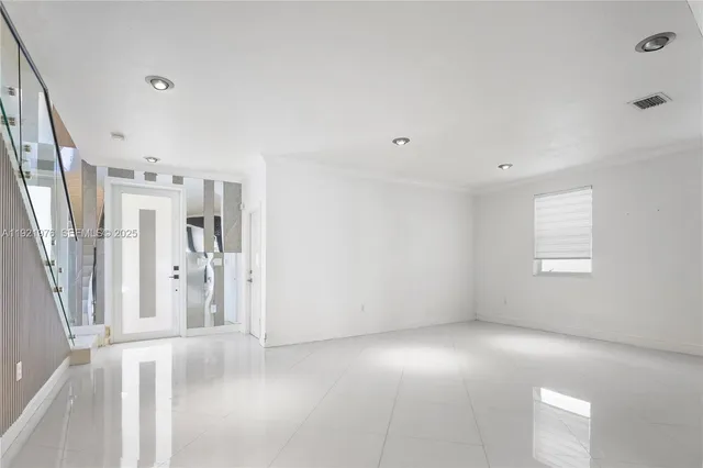 a view of empty room with wooden floor and window