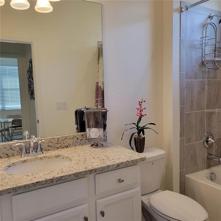 17335 Blue Ridge Place Bradenton, FL 34211 - Photo 19 of 44 a bathroom with a granite countertop sink a toilet and a mirror