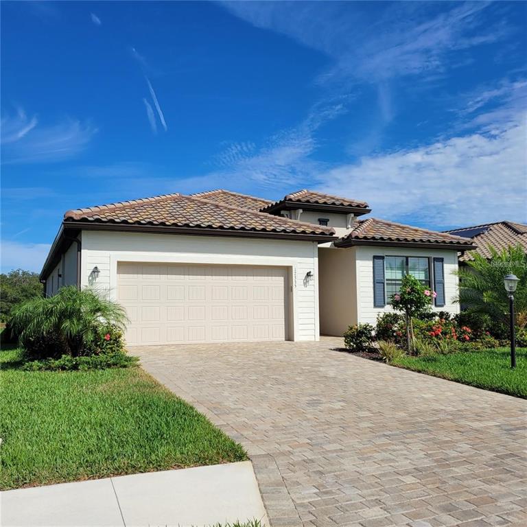 17335 Blue Ridge Place Bradenton, FL 34211 - Photo 2 of 44 a front view of a house with a garden and plants