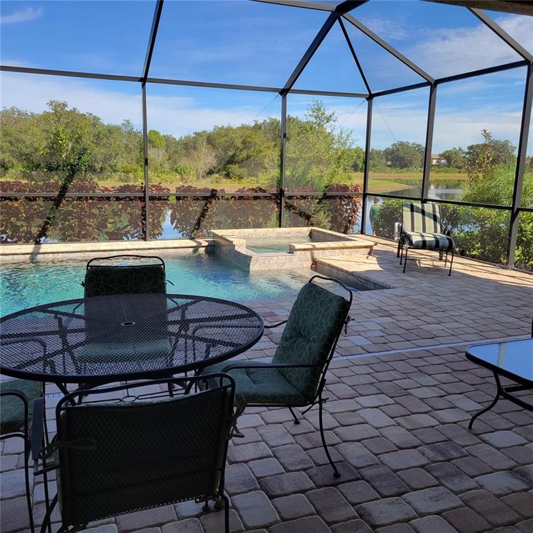 17335 Blue Ridge Place Bradenton, FL 34211 - Photo 23 of 44 a view of a swimming pool with a table and chairs under an umbrella