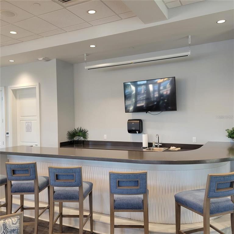 17335 Blue Ridge Place Bradenton, FL 34211 - Photo 35 of 44 a kitchen with a dining table chairs and a flat screen tv