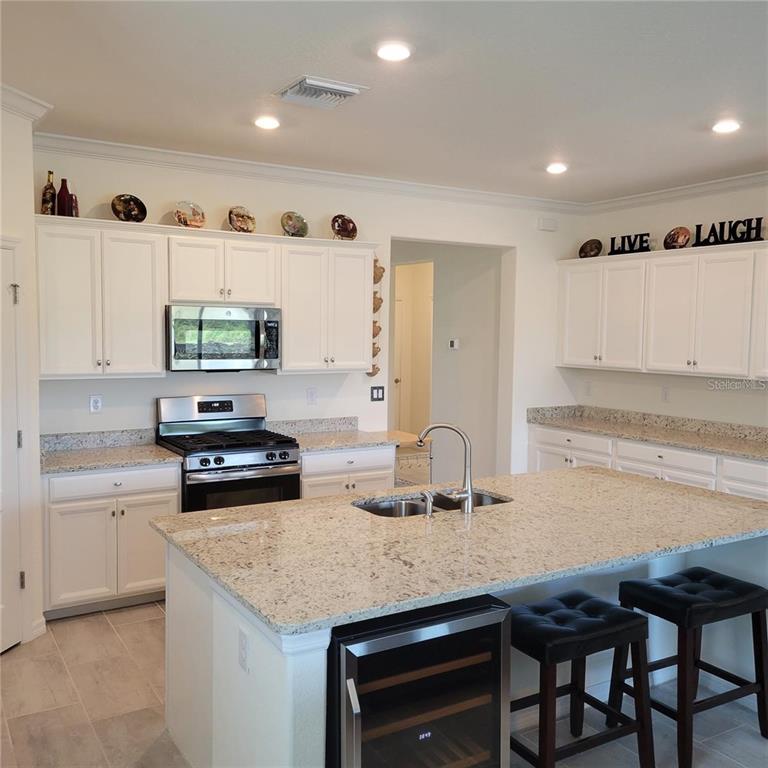 17335 Blue Ridge Place Bradenton, FL 34211 - Photo 5 of 44 a kitchen with granite countertop a stove a sink and a refrigerator